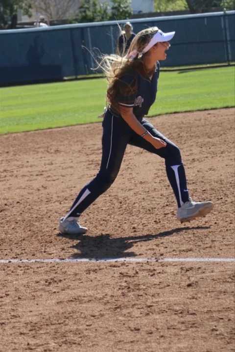 Softball infield action in a navy uniform